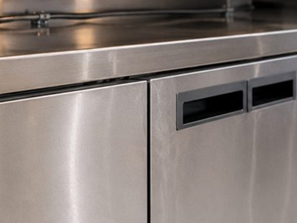 Bancada e superfícies de aço inox em cozinha industrial de fast-food.