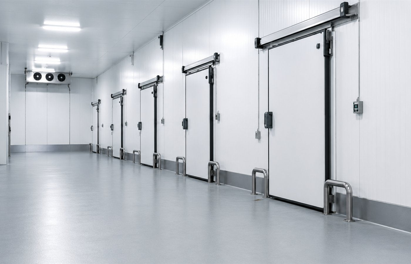 Corredor interno de câmara frigorífica com piso industrial e portas isotérmicas.